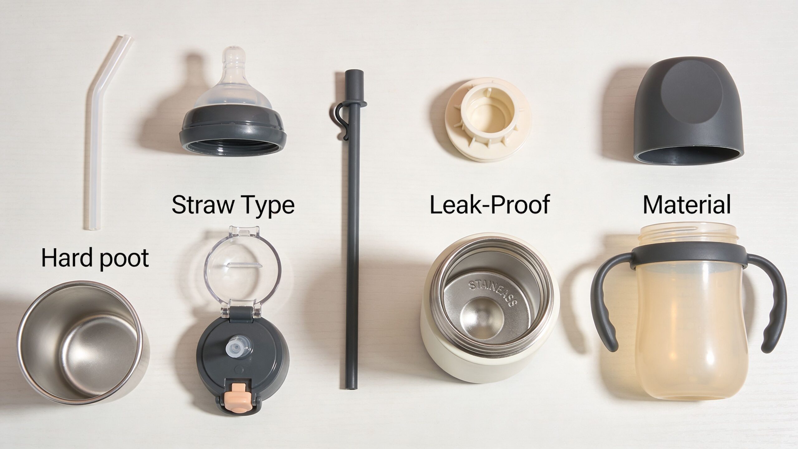 A collection of disassembled baby sippy cup components, including bottles, lids, straws, and handles laid flat.